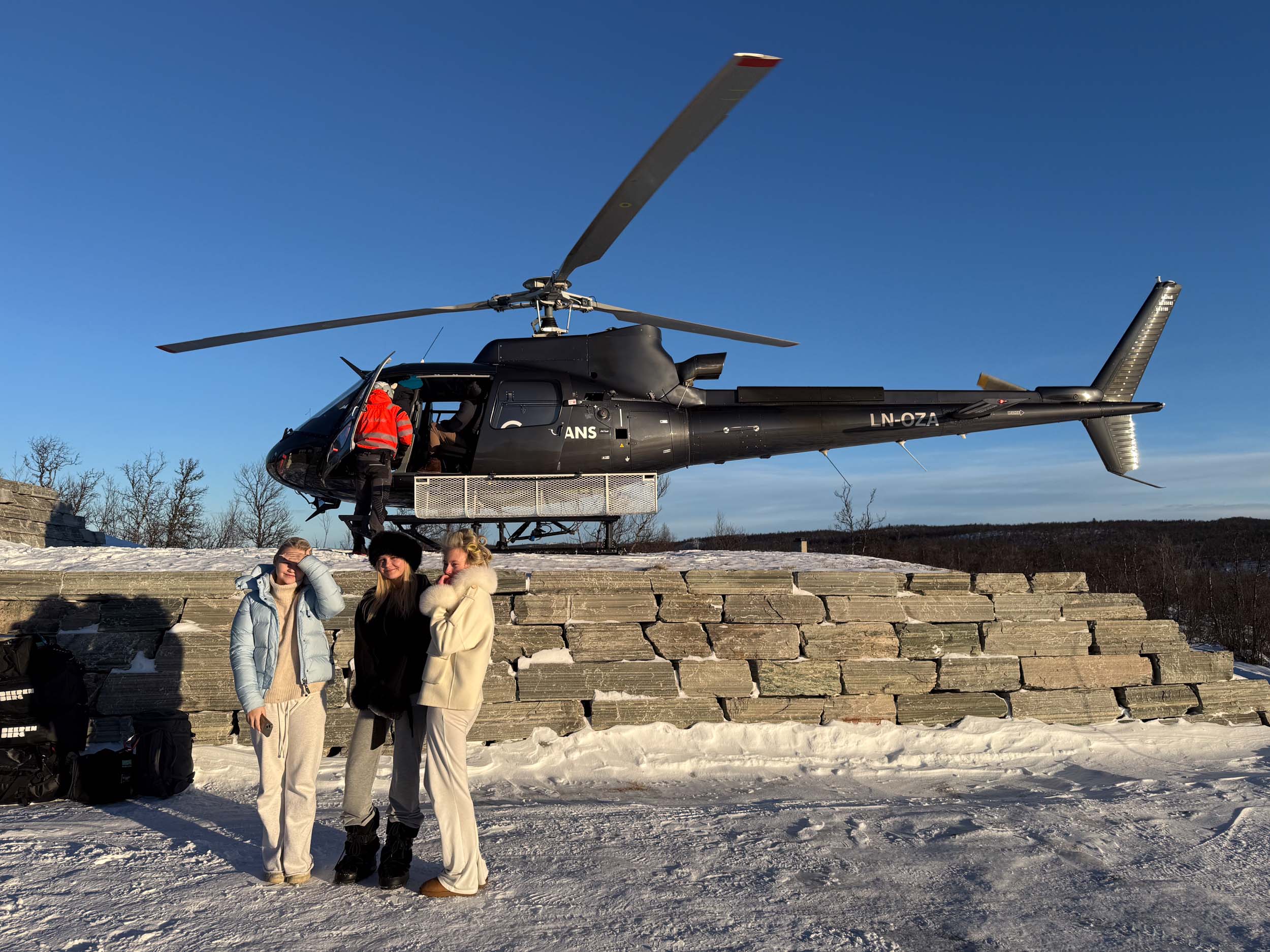 Bilde av tre jenter som har tatt helikopter opp til hytten
