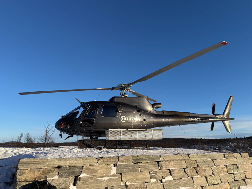 Bilde av et helikopter som har landet ved en hytte i Geilo
