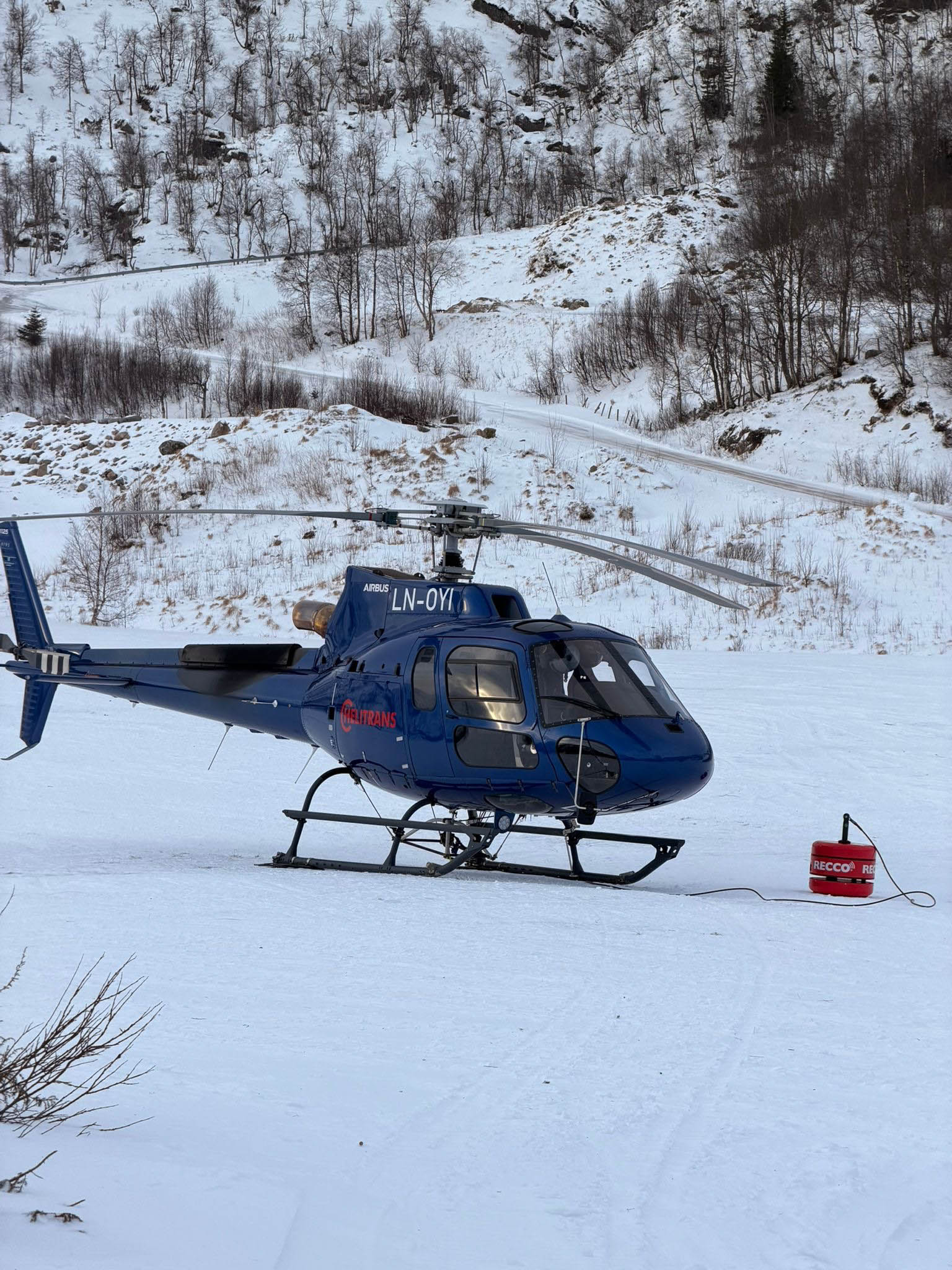 Bilde av et blått helikopter som står stasjonert på snøen