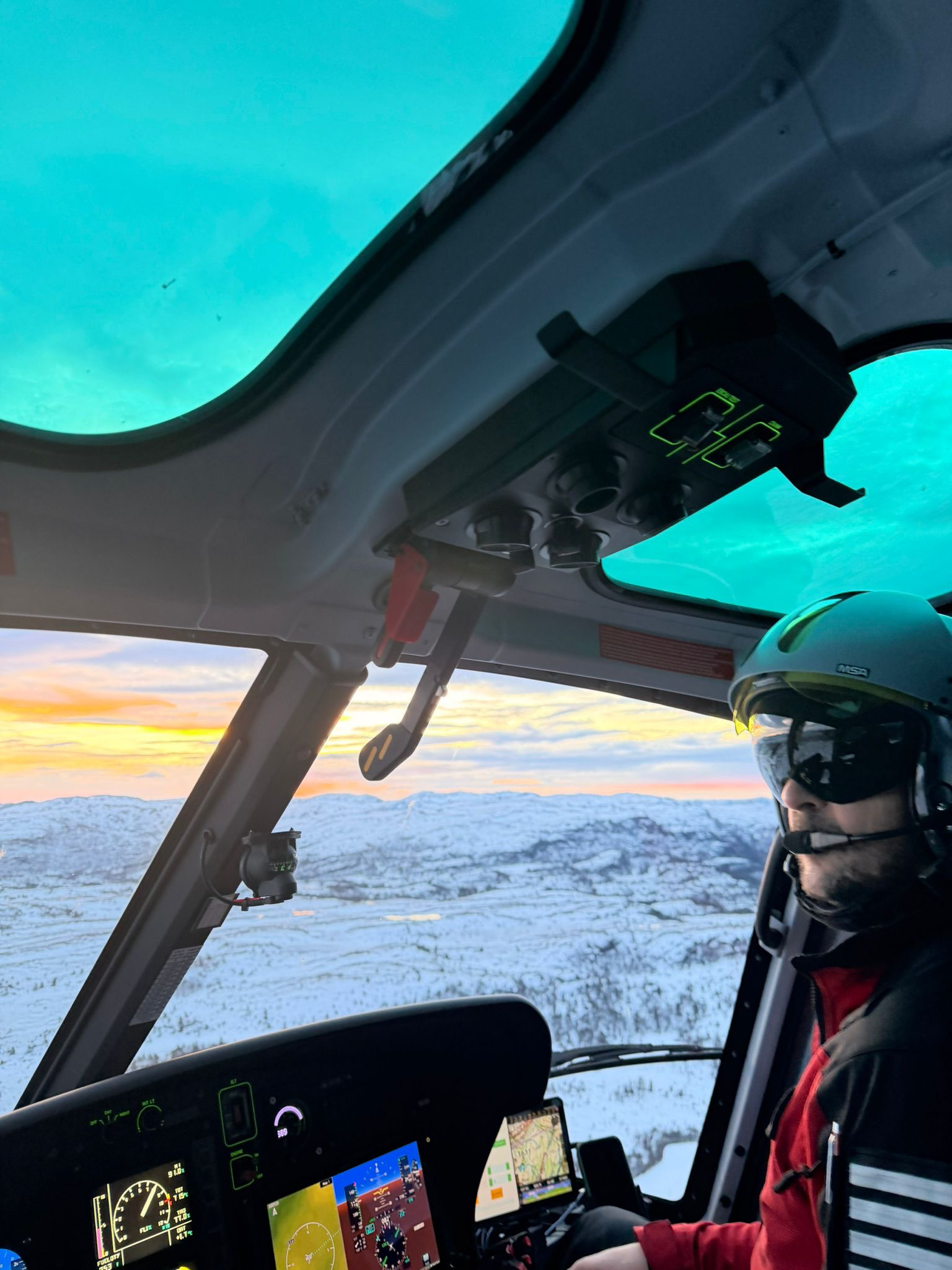 Bilde av en helikopterpilot som er ute og flyr